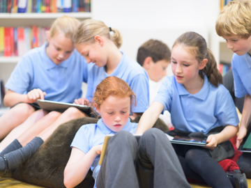 BEN - School Kids sitting in a group looking at tablets and iphones (1)
